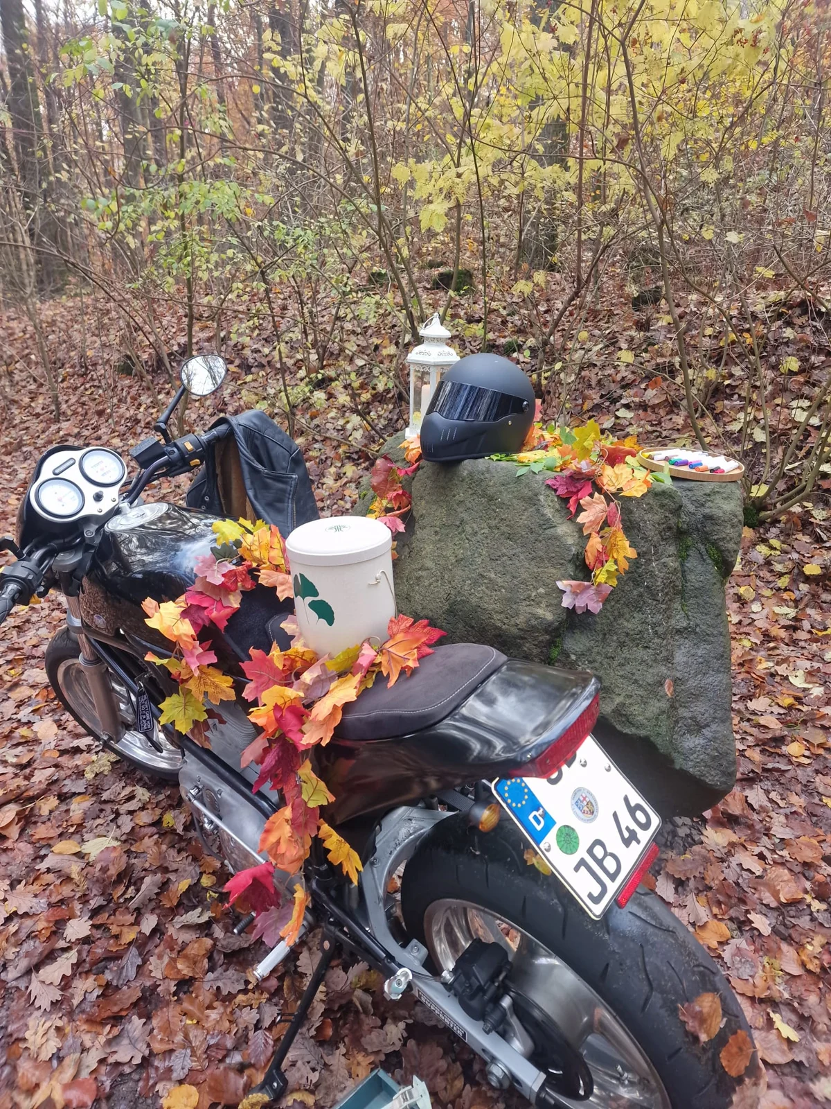 Persönliche Abschiedsgestaltung im Wald mit Motorrad und Blumen