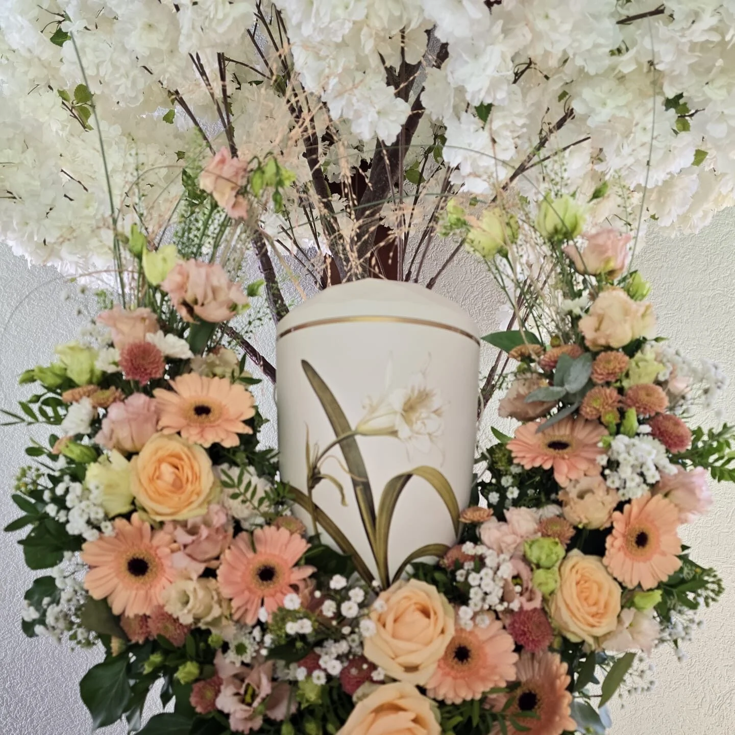 Urne mit cremefarbenen und rosafarbenen Blumen