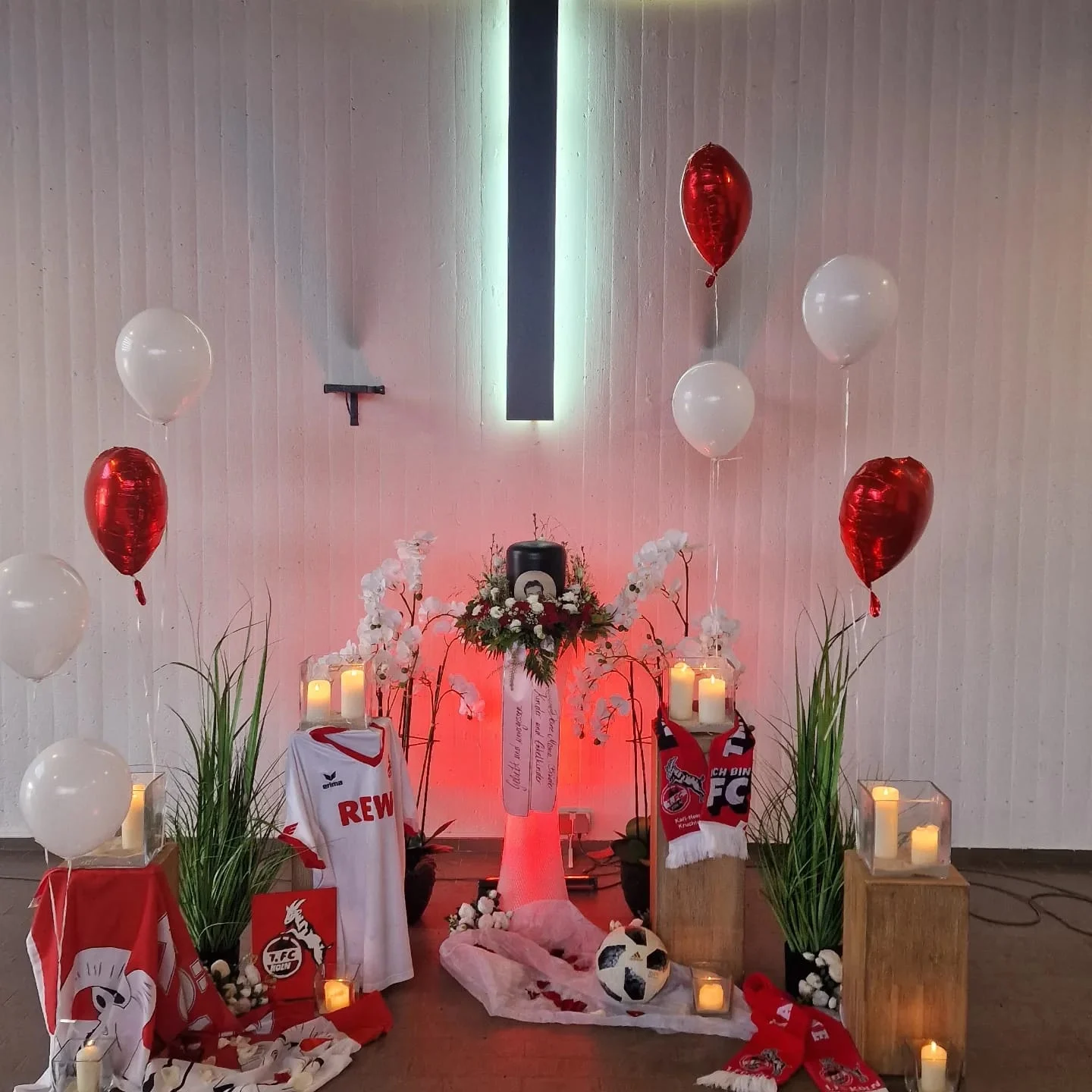 Individuell gestalteter Abschiedsraum mit roten Blumen und Ballons